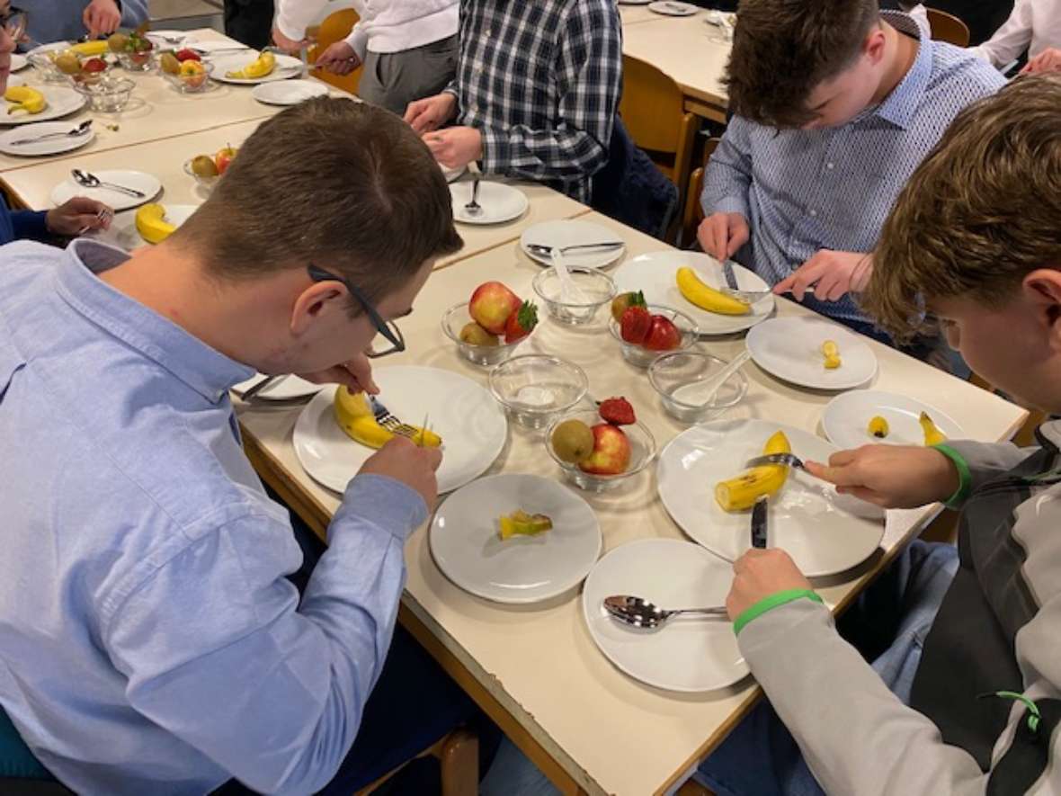 Schüler beim Zubereiten von Obstsalat