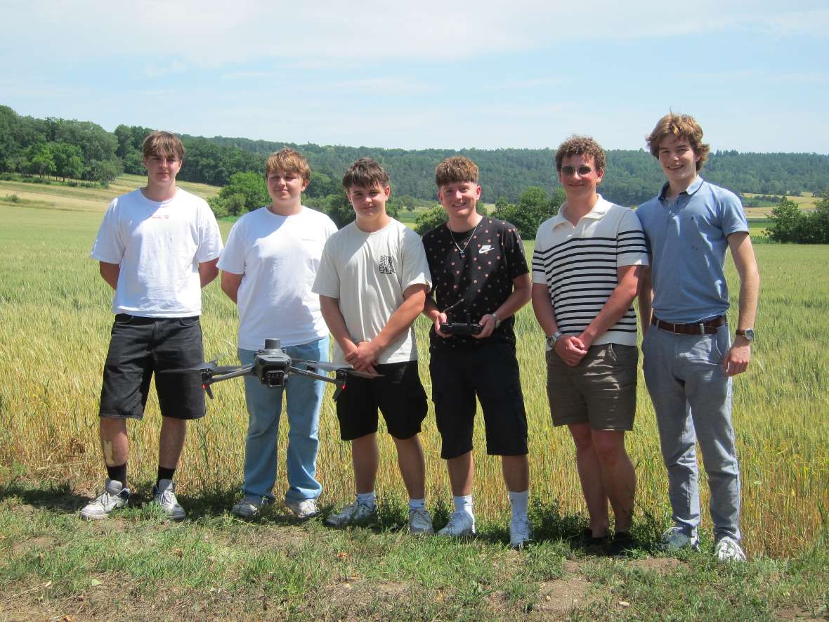Schülergruppe mit Drohne