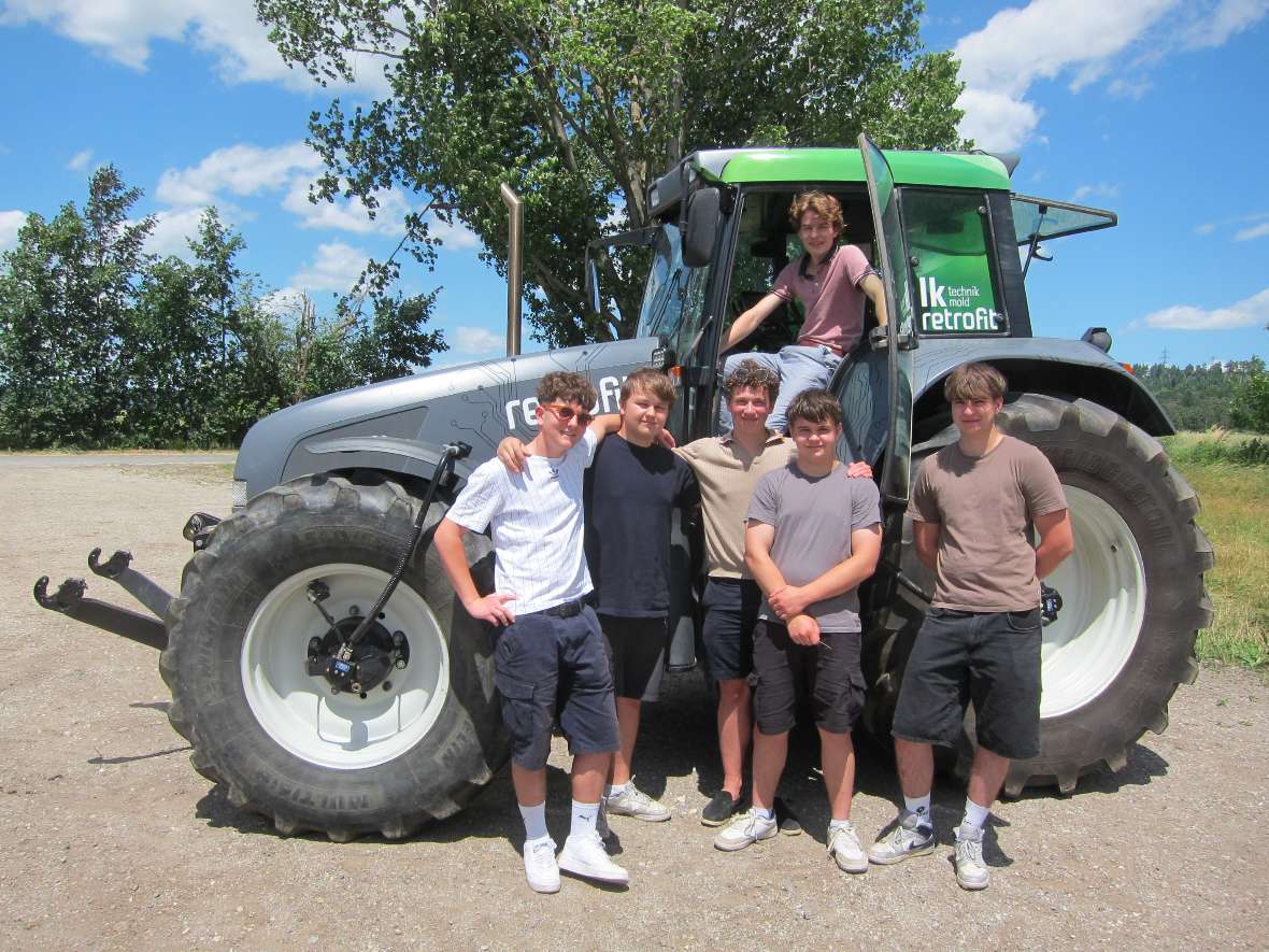 Schülergruppe vor Traktor